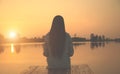 Silhouette of relaxing young woman on wooden pier at the lake in sunset Royalty Free Stock Photo