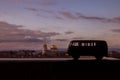 Silhouette of a retro bus Model Volkswagen Volkswagen 2 toy in a cloudy sky at sunset. In the distance you can see the golden Royalty Free Stock Photo