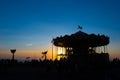 Silhouette of a retro carousel at sunset