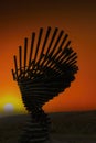 The silhouette of the Ringing Singing Tree in Lancashire, UK against an orange sky