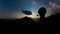 Silhouette of a rock climber descending on the rope after climbing at sunset