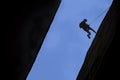 Silhouette of rock climber rappelling