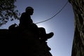 Silhouette of a rock climber sitting on a ledge while supporting his teammate in Torrelodones, Madrid. Extreme sports