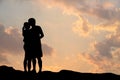 Silhouette of romantic a couple hug kissing against a sunset sky Royalty Free Stock Photo