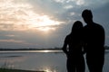 The silhouette of a romantic couple standing, hugging each other and watching the sunset. Romance and love concept Royalty Free Stock Photo