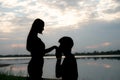 The silhouette of a romantic couple standing, hugging each other and watching the sunset. Romance and love concept Royalty Free Stock Photo