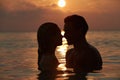 Silhouette Of Romantic Couple Standing In Sea