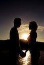 Silhouette of romantic happy couple in love holding hands on the sunset Royalty Free Stock Photo