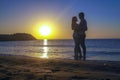 Silhouette of romantic lovers meeting sunrise sunset on the sea coast Royalty Free Stock Photo