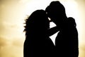 Silhouette of a romantic young couple kissing with the beautiful view of sunset in the background Royalty Free Stock Photo