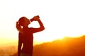 Silhouette of a runner drinking water from bottle Royalty Free Stock Photo