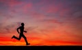 Silhouette of running man on sunset fiery sky background Royalty Free Stock Photo