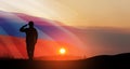 Silhouette of russian soldier in uniforms on background of sunset sky with the Russian flag.