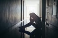 Silhouette of sad and depressed women sitting at walkway of condominium or office