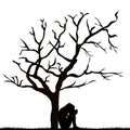 Silhouette of a sad woman under a leafless tree Royalty Free Stock Photo