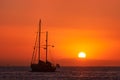 Silhouette of sailing boat with sails down against sun at sunset, sun glare on sea waters. Romantic seascape. Holiday Royalty Free Stock Photo