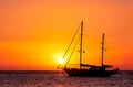 Silhouette of sailing boat with sails down against sun at sunset, sun glare on sea waters. Romantic seascape, sun touch Royalty Free Stock Photo