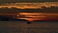 Silhouette of sailing boat in the water after sunset in English Bay, Vancouver, Canada with the mountains of Vancouver Island.