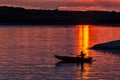 Silhouette of a sailor in a kayak canoe on the lake in the sunset light near an island, Danube River Royalty Free Stock Photo