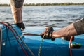 Silhouette of a sailors hands on a winch rope on a sailboat on a sunset. Shot with a selective focus. Royalty Free Stock Photo