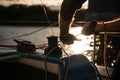 Silhouette of a sailors hands on a winch rope on a sailboat on a sunset. Shot with a selective focus. Royalty Free Stock Photo