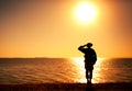 Silhouette of saluting on shore commando solder Royalty Free Stock Photo