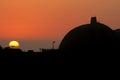 Silhouette of San Onofre nuclear power plant main reactors at sunset with the sun visible