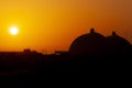 Silhouette of San Onofre nuclear power plant main reactors at sunset with sun visible