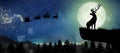 Silhouette of Santa Claus flying over the full moon