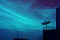 Silhouette of Satellite Dish on the High Building Against Evening Sky in Blue Color Tone