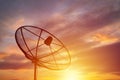 Silhouette of satellite dish on sunset background