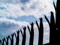 Silhouette of a security anti climbing fence. Dramatic blue cloudy sky. Concept safety, defense, private property protection