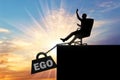 Silhouette of a selfish boss sitting in a chair and a heavy load of ego, pulling him into the abyss Royalty Free Stock Photo