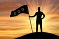 Silhouette of a selfish man with a crown on his head holds a flag with the word ego on top of a hill