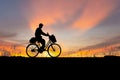 Silhouette of Senior Asian man riding a bicycle at sunset in evening time Royalty Free Stock Photo