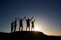 Silhouette Of Senior Friends Standing On Rocks By Sea On Vacation At Sunset With Arms Outstretched Royalty Free Stock Photo