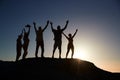 Silhouette Of Senior Friends Standing On Rocks By Sea On Vacation At Sunset With Arms Outstretched Royalty Free Stock Photo