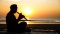 Silhouette of senior man playing bamboo flute on the beach at sunset Royalty Free Stock Photo