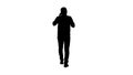 Silhouette Serious man walking and talking on his cellphone. Royalty Free Stock Photo