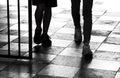 Silhouette shadow of two teenage boys walking through the gate, detail of legs in black and white