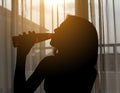 Silhouette shot of a female drinking red wine