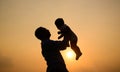 Silhouette shot of happy father holding newborn baby with sunset view Royalty Free Stock Photo
