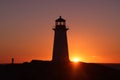 Peggy\'s Cove Lighthouse, Halifax, Nova Scotia, Canada. Silhouette shot of a lady taking a picture of a lighthouse.