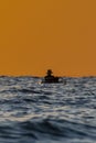 Silhouette shot of a man on a small boat fishing to the sea Royalty Free Stock Photo