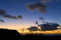 Silhouette shot of the moai statues over a background of a sunset at Easter Island