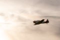 Silhouette shot of vintage military aircraft flying during sunset