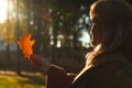 Silhouette side view of smiling woman looking at oak tree leaf. Mental health, hope, happiness concept. Dream autumn. Peace