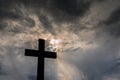 Silhouette of a simple catholic cross, dramatic stormclouds after heavy rain