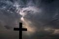 Silhouette of a simple catholic cross, dramatic stormclouds