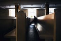 Silhouette of sinful man praying in church seating on pews Royalty Free Stock Photo